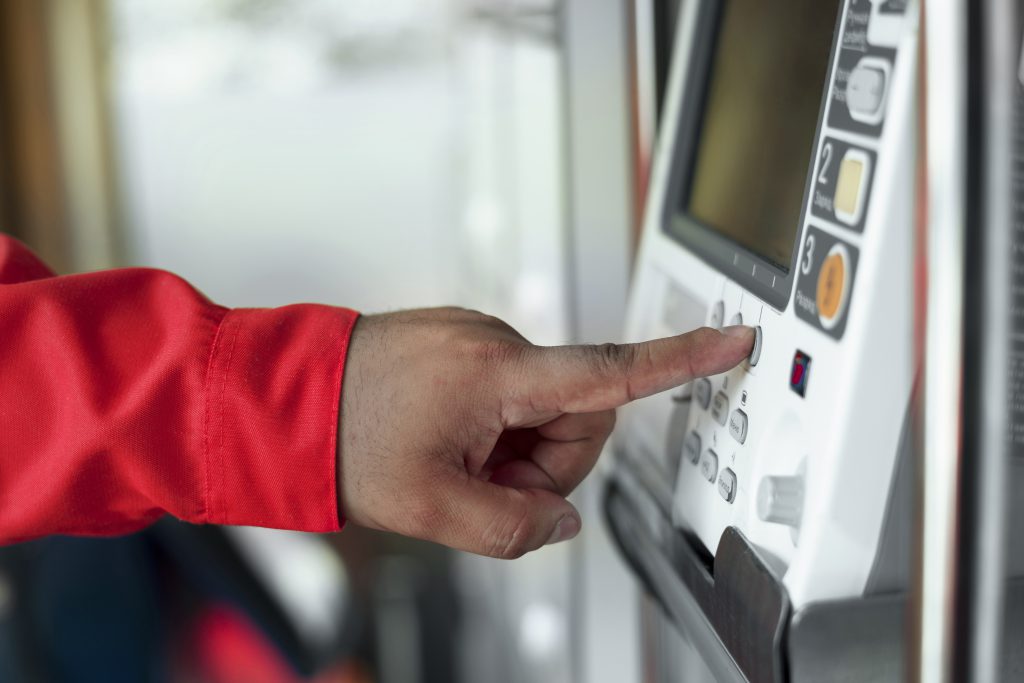 mężczyzna wciska przycisk na maszynie - automatyka budynkowa kraków