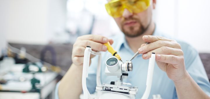 Specjalista serwisujący elementy urządzenia laboratoryjnego w trakcie naprawy kruszarki