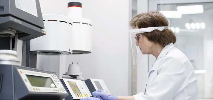 Technik laboratoryjny analizujący próbki na stanowisku z kruszarką laboratoryjną Tarnów.